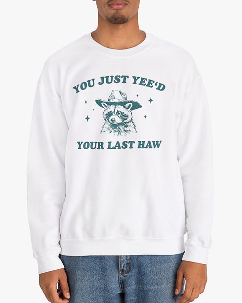 Man wearing white 'You Just Yeed Your Last Haw' sweatshirt with funny retro cowboy raccoon graphic